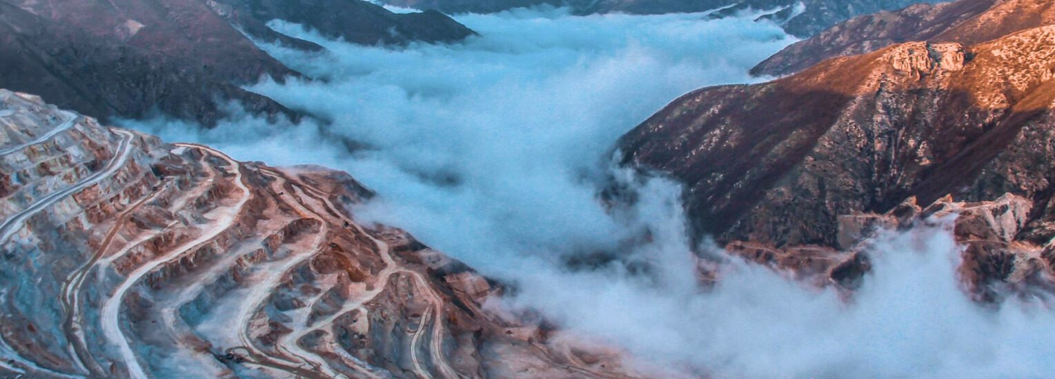 Aerial view of a mining operation in an emerging market, showcasing heavy machinery extracting natural resources.